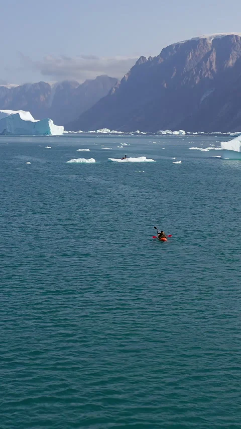 Vertical Aerial Back Follow of Kayaker Paddling Across Greenland Fjord Among Video stock 346397080