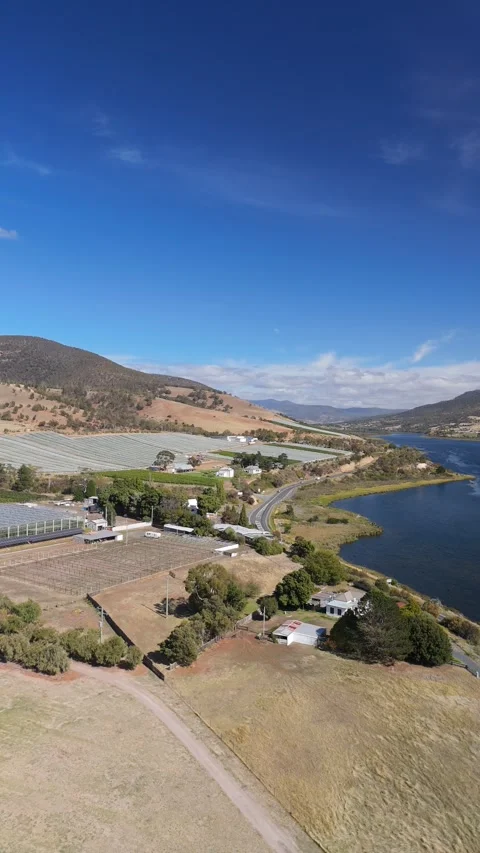 Vertical aerial of the Derwent River valley with greenhouses and mountains. Stock-Footage 332542591