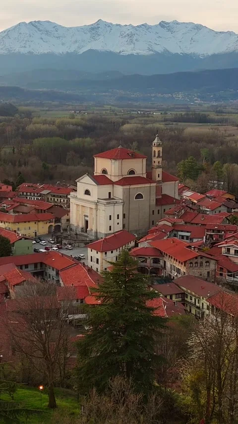 Vertical aerial drone shot pulling back from historic Italian church to reveal Vidéo 330947585