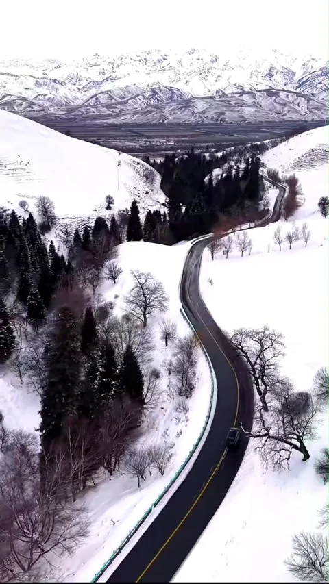 Vertical Aerial Drone Tracking Shot of a Black Car Driving on a Winding Moun Stock Footage 326584280