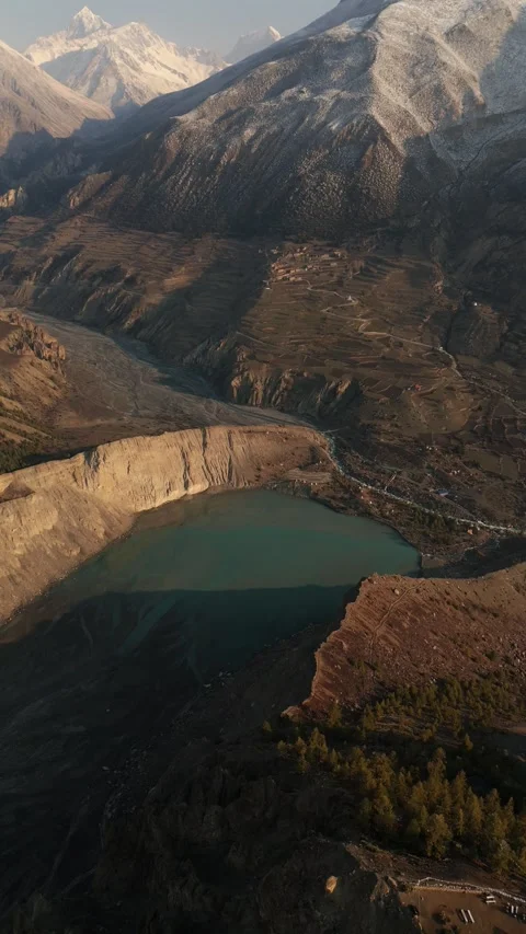 Vertical Aerial drone view of turquoise mountain lakes cradled by snowy giants. Stock Footage 311019226