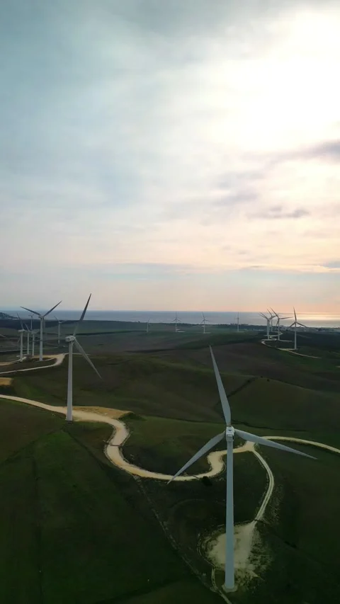 Vertical aerial drone view of wind mill turbine farm with ocean in the back.. Stock Footage 293064142