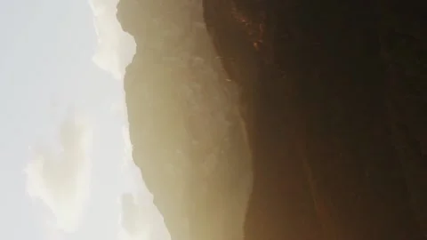 Vertical aerial flight above mountain range lit with golden morning sunlight Stock Footage 166757069