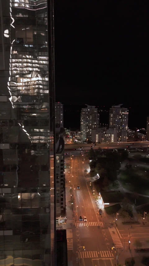Vertical aerial of glass tower reflection with Toronto waterfront road at night Stock Footage 333888695