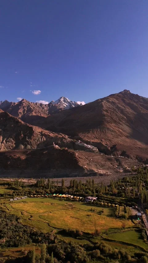 Vertical aerial reveal of Diskit Monastery standing firm against Nubra’s wild Stock Footage 310900854