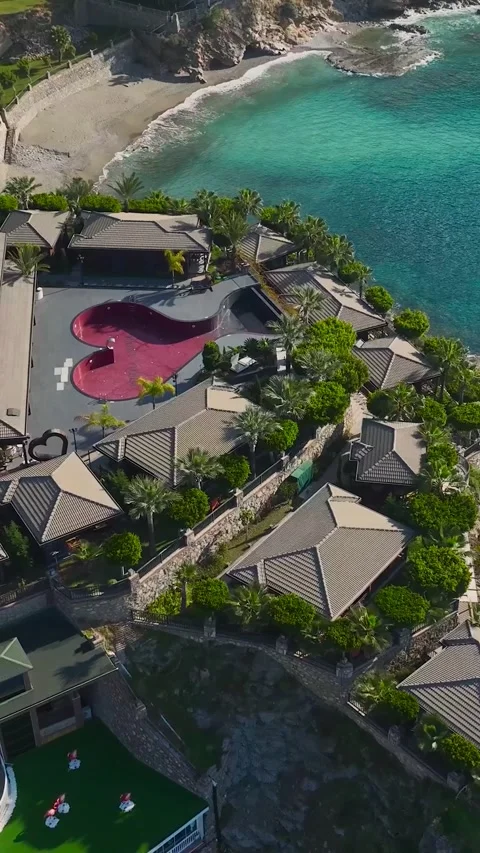 Vertical Aerial Shot Cliffside Resort with Palm Trees and Private Relaxation 库存影片 341704656