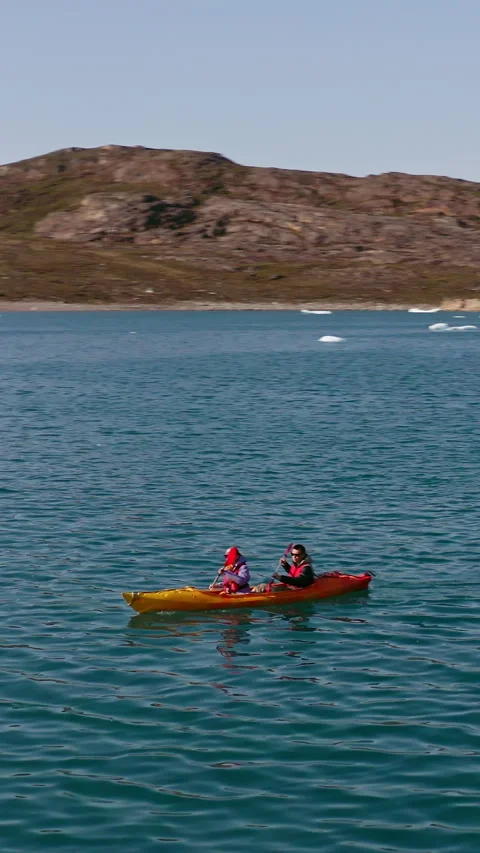 Vertical Aerial Side Follow View of People Kayaking Across Cold Greenland Waters Stock Footage 346494100