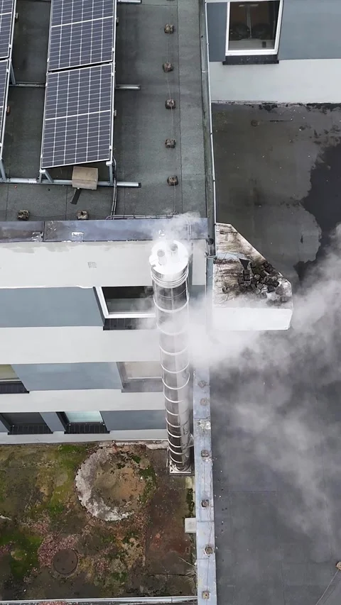 Vertical Aerial Static Pan of Smoking Chimney on Roof with Solar Panels Video stock 323965624