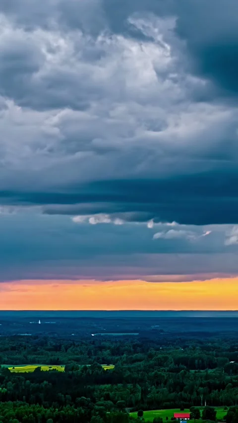 Vertical aerial time lapse dramatic clouds golden rays rural Latvia landscape Stock Footage 328226022