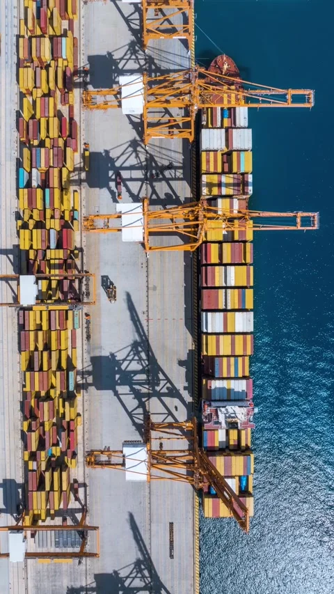 Vertical aerial time lapse view of large container cargo ship being unloaded Video stock 310832909