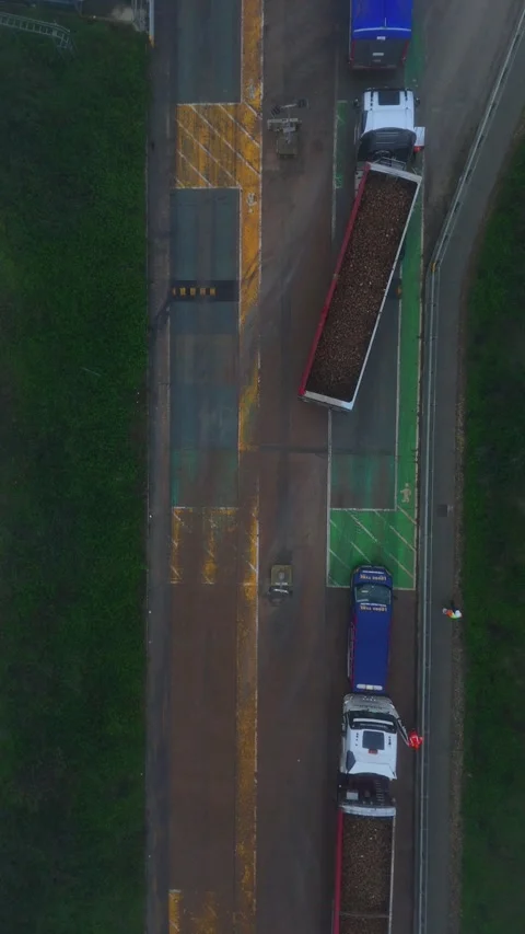 Vertical aerial top down view of HGV trucks loaded with sugar beet queuing to 스톡 동영상 328959392