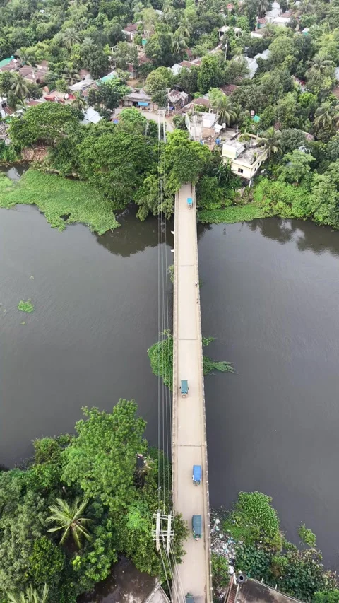 Vertical aerial top down view of a narrow bridge crossing a rural river Stock Footage 341526419
