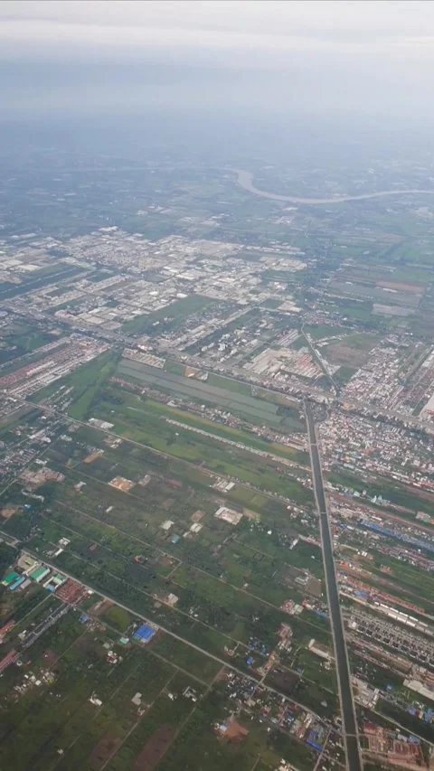 Vertical aerial view from an airplane window featuring a city with organized roa Stock Footage 331888132