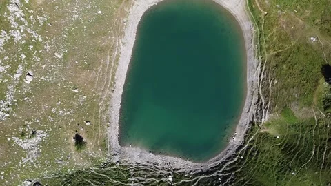 Vertical aerial view of an alpine green lake Stock Footage 137394285