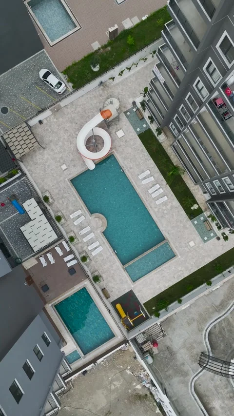 Vertical Aerial View Contemporary Pool Area with Light Stone Texture and Blue Stock Footage 341775579