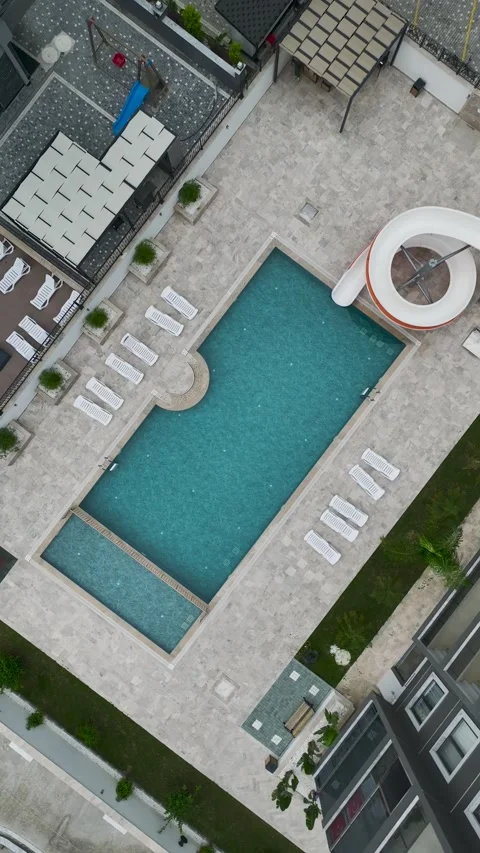 Vertical Aerial View Contemporary Pool Area with Light Stone Texture and Blue Stock Footage 341775688