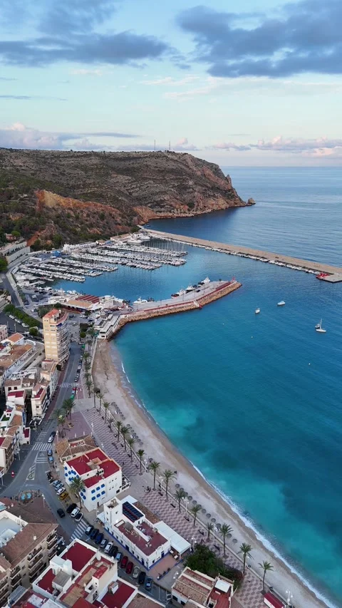 Vertical aerial view of curved beach and marina at dusk, Javea, Spain Stock Footage 339892454