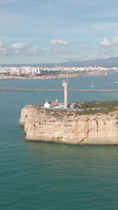 Vertical Aerial View of Ferragudo Lighthouse and Rugged Algarve Cliffs Stock Footage 346776636