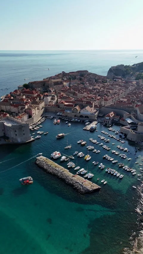 Vertical aerial view of a historic harbor and medieval city walls Stock-Footage 345118018