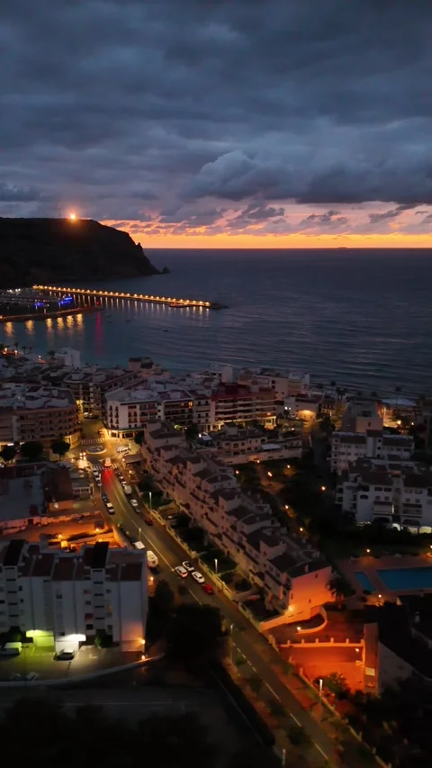 Vertical aerial view of illuminated pier at dramatic sunset, Javea, Spain Stock Footage 339989895