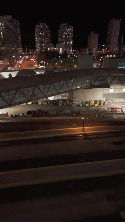 Vertical aerial view of lit Toronto road tunnel and train tracks at night 스톡 동영상 333887207