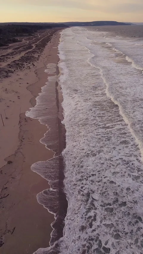 Vertical Aerial View of Long Sandy Beach and Foamy Sea Waves Видео 347068940