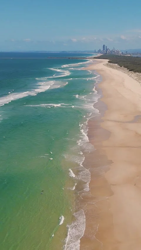 Vertical Aerial View of Ocean Waves Crashing on Sandy Beach Shoreline Vídeo Stock 329534188