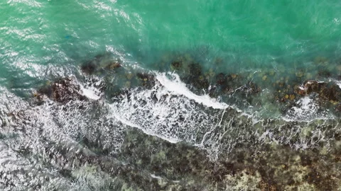 Vertical Aerial View of Ocean Waves Breaking Across Coral Reef 库存影片 340892224