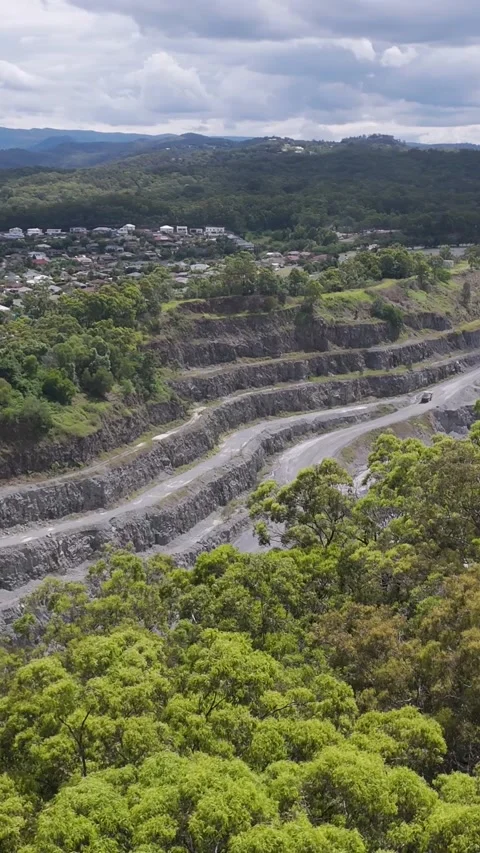 Vertical Aerial View of Open Pit Quarry and Lush Green Forest Vídeo Stock 329537195