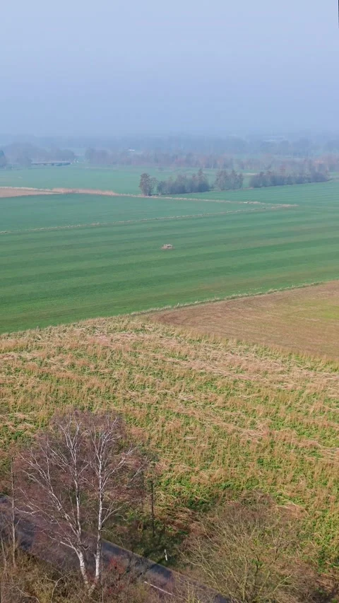Vertical aerial view of patchwork agricultural fields in a misty rural land Stockbeeldmateriaal 332741913