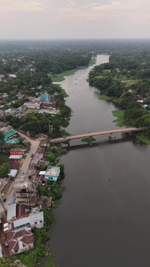 Vertical aerial view of a river bridge and green countryside landscape Stock Footage 341520259