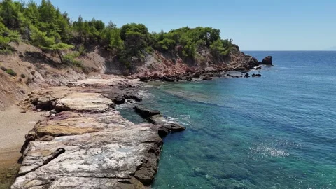 Vertical aerial view of rocky cliffs and clear blue water along the coast. Stock Footage 327674175