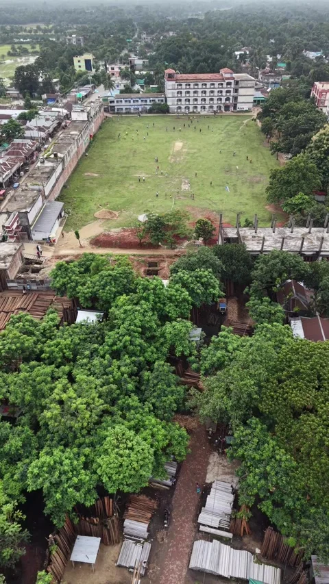 Vertical aerial view of a school building with a large green playground Stock Footage 341526448