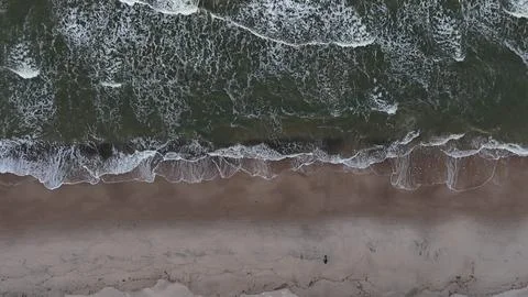Vertical Aerial View of Sea Waves Rolling Onto a Sandy Beach Stock Photos