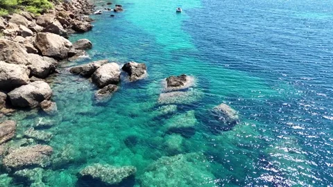 Vertical aerial view of a single boat in clear turquoise sea water. Stock Footage 327675427