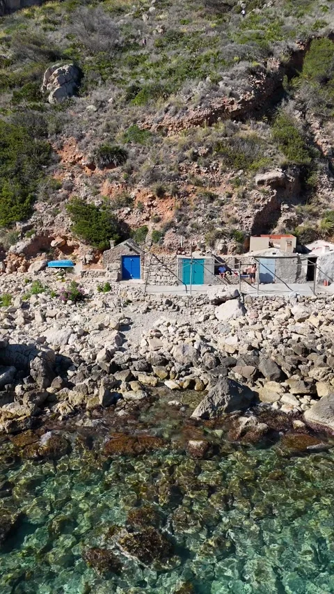 Vertical aerial view of stone huts with blue doors, Cala Llebeig, Spain Stock Footage 340238980