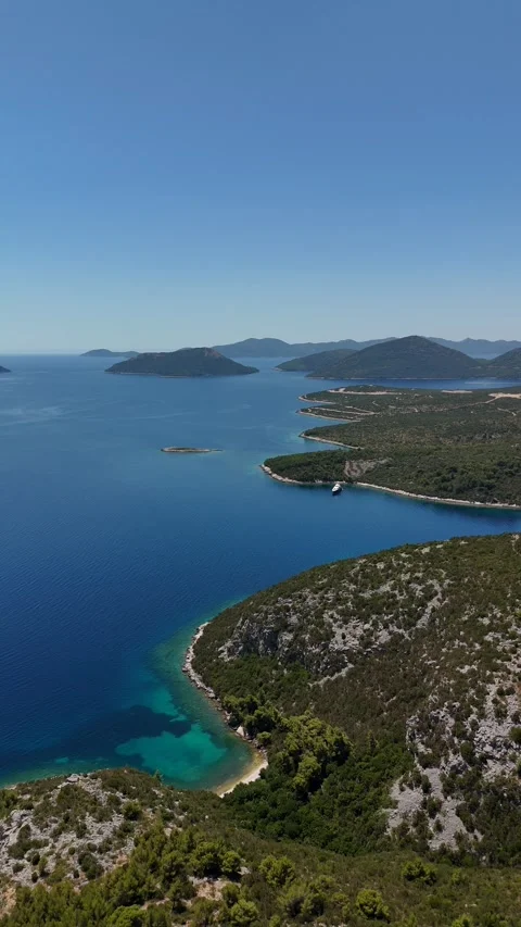 Vertical aerial view of a turquoise Adriatic bay and green islands Stock Footage 345118664