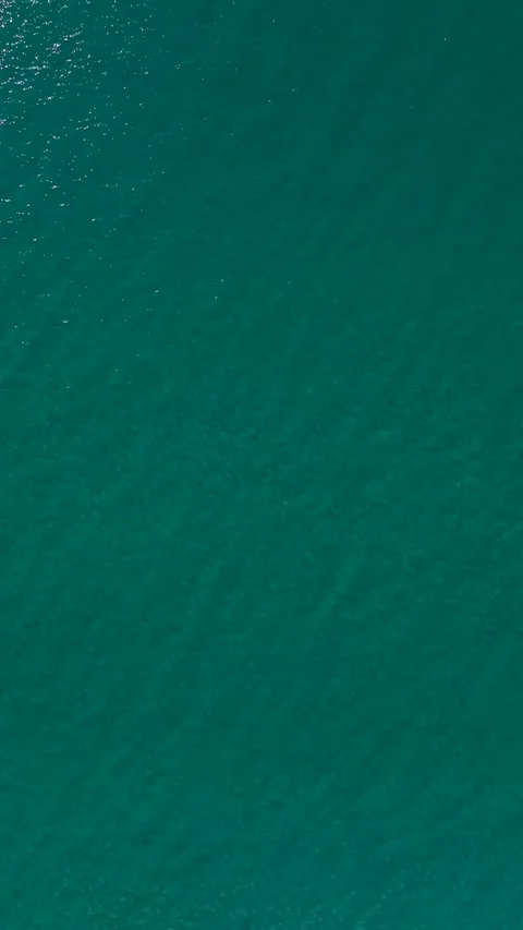 Vertical aerial view of turquoise water with soft wave patterns and reflections Stock Footage 341834817
