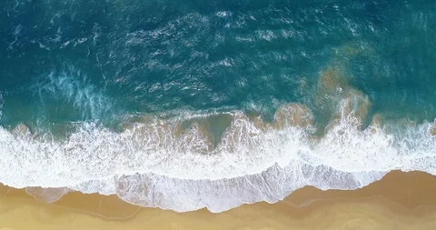 Vertical aerial view of turquoise waves lapping golden beach Stock Footage 87573176
