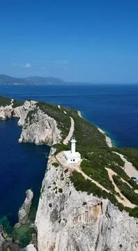 Vertical Aerial View of White Lighthouse on Steep Ocean Cliff Stock-Fotos