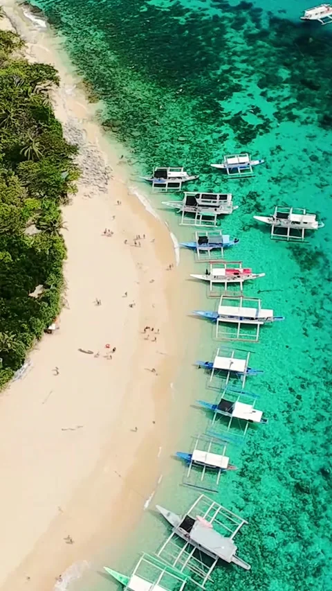 Vertical aerial view of white sand beach with turquoise water and boats in El Stockbeeldmateriaal 319673348