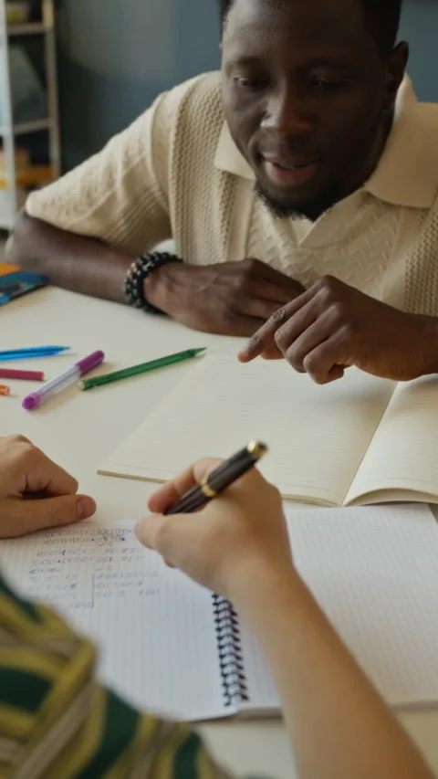 Vertical of African American Tutor Explaining Math Equations to Student Stock Footage 340547142