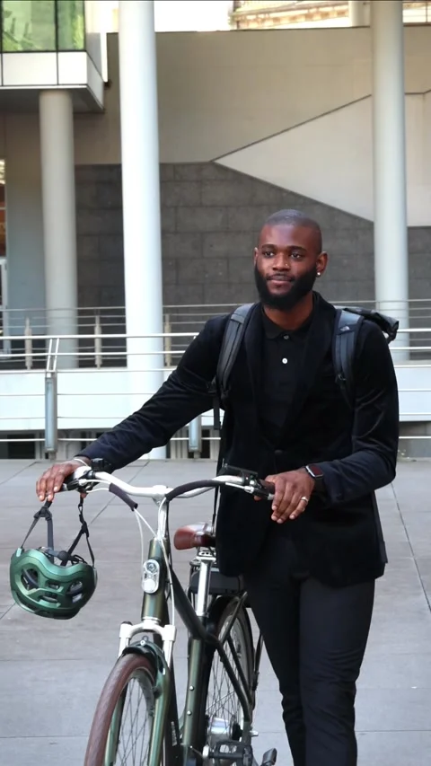 Vertical African businessman with backpack walking beside electric bike to .. Stock Footage 280026410
