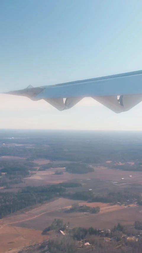 Vertical airplane window view above rural landscape during a rough, shaky Stock Footage 335892540