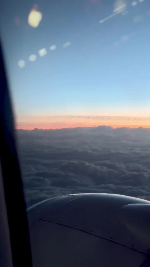 Vertical Airplane Window View of Wing and Sunrise Clouds. Video stock 335999610