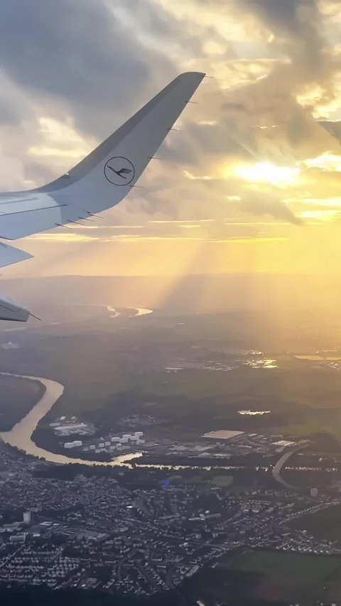 Vertical airplane wing view over Frankfurt at sunset, with golden sun rays Stock Footage 339754568