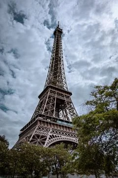 Vertical and low-angle shot of the Eiffel Tower on a cloudy day in Paris Stock Photos