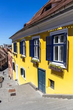 Vertical Angle of Historic Yellow Building with Blue Shutters Stock Photos
