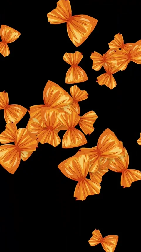 Vertical Animation of Wrapped Orange Candies Bursting on Black Background Stock Footage 344843426