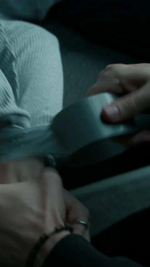 Vertical of Anonymous Criminal Tying Hands of Hostage with Duct Tape Stock Footage 294700018